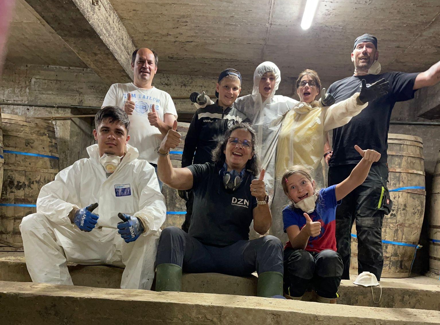 Gruppenfoto von acht Helfenden nach der Arbeit im von der Flut betroffenen Weinkeller