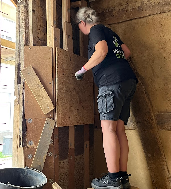 Helferin im Fluthaus beim Renovieren einer Wand