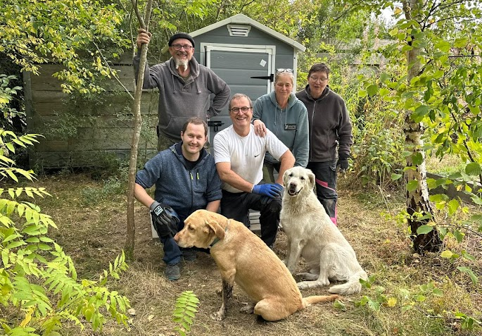 Gruppenfoto mit 5 Helfenden und zwei Hunden im Garten